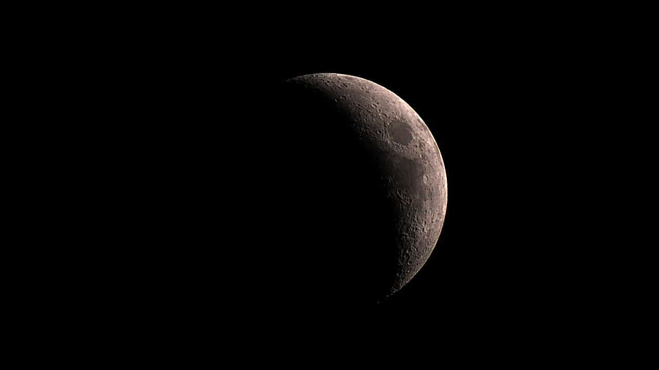 A waxing crescent moon against a black sky.
